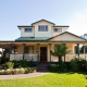Beautiful Victorian-style house with a spacious front porch and lush garden in Sydney.