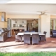 Outdoor dining area with built-in BBQ and open-plan kitchen.
