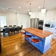 Spacious kitchen featuring a central island, white cabinetry, and a dining table with eight chairs i.