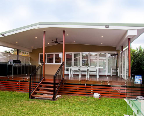 Covered outdoor deck with dining space and BBQ in a Sydney backyard.