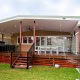 Covered outdoor deck with dining space and BBQ in a Sydney backyard.