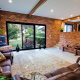 Modern living room with brick walls, large glass doors, and cozy furniture in Sydney home.