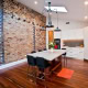Interior view of a contemporary kitchen with brick accent wall and white cabinetry.