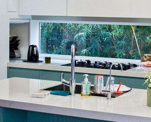 Contemporary kitchen interior with white cabinets, a central island, and modern appliances in a Sydn.