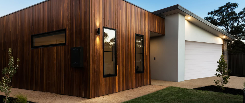 A contemporary Sydney home with wooden cladding and a white garage, showcasing modern design and ext.
