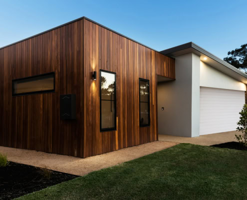 A contemporary Sydney home with wooden cladding and a white garage, showcasing modern design and ext.