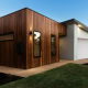 A contemporary Sydney home with wooden cladding and a white garage, showcasing modern design and ext.