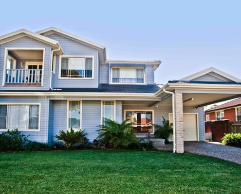 A spacious two-story Sydney home featuring a well-maintained lawn, front porch, and contemporary ext.