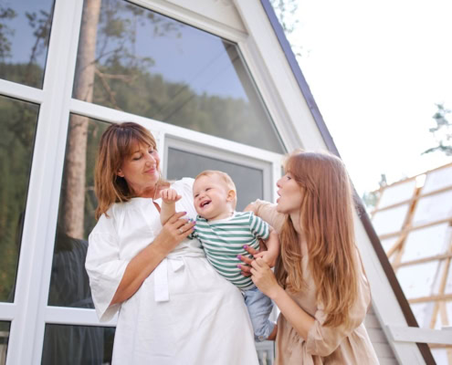 Family enjoying quality time in a modern, sunlit home with large windows.
