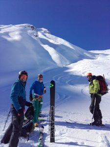 Group of skiers and splitboarders on snowy mountain in Pisa Range, NZ.