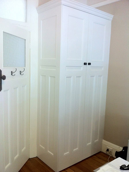White built-in wardrobe with double doors in Sydney home.