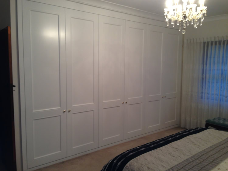 Custom built wardrobe with white cabinetry in a Sydney bedroom.