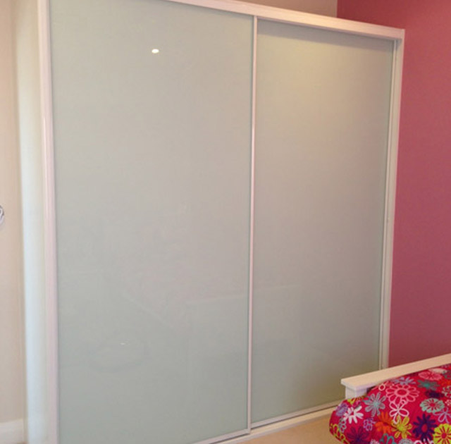 White sliding wardrobe with sleek design, ideal for Sydney bedrooms and storage solutions.