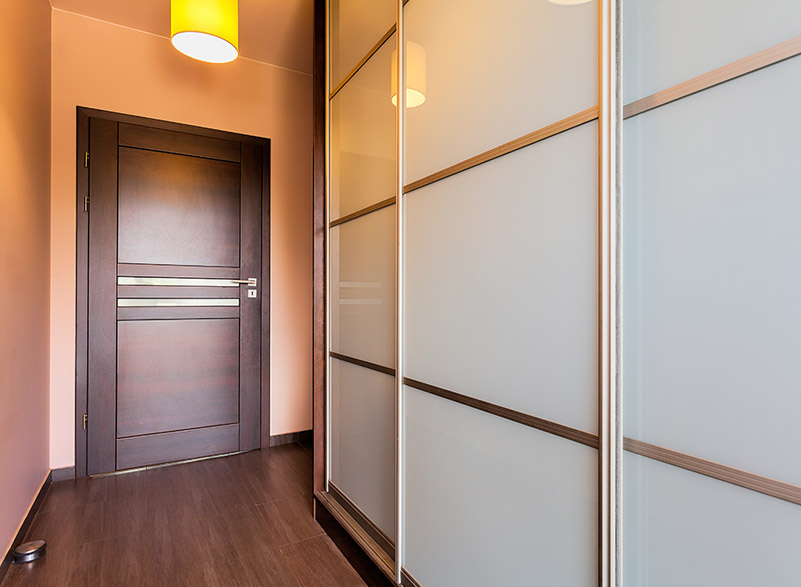Sliding wardrobe doors in a contemporary bedroom, showcasing sleek design and quality craftsmanship.