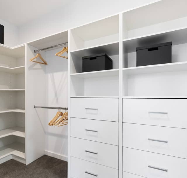 Modern walk-in wardrobe with drawers and storage boxes in Sydney.