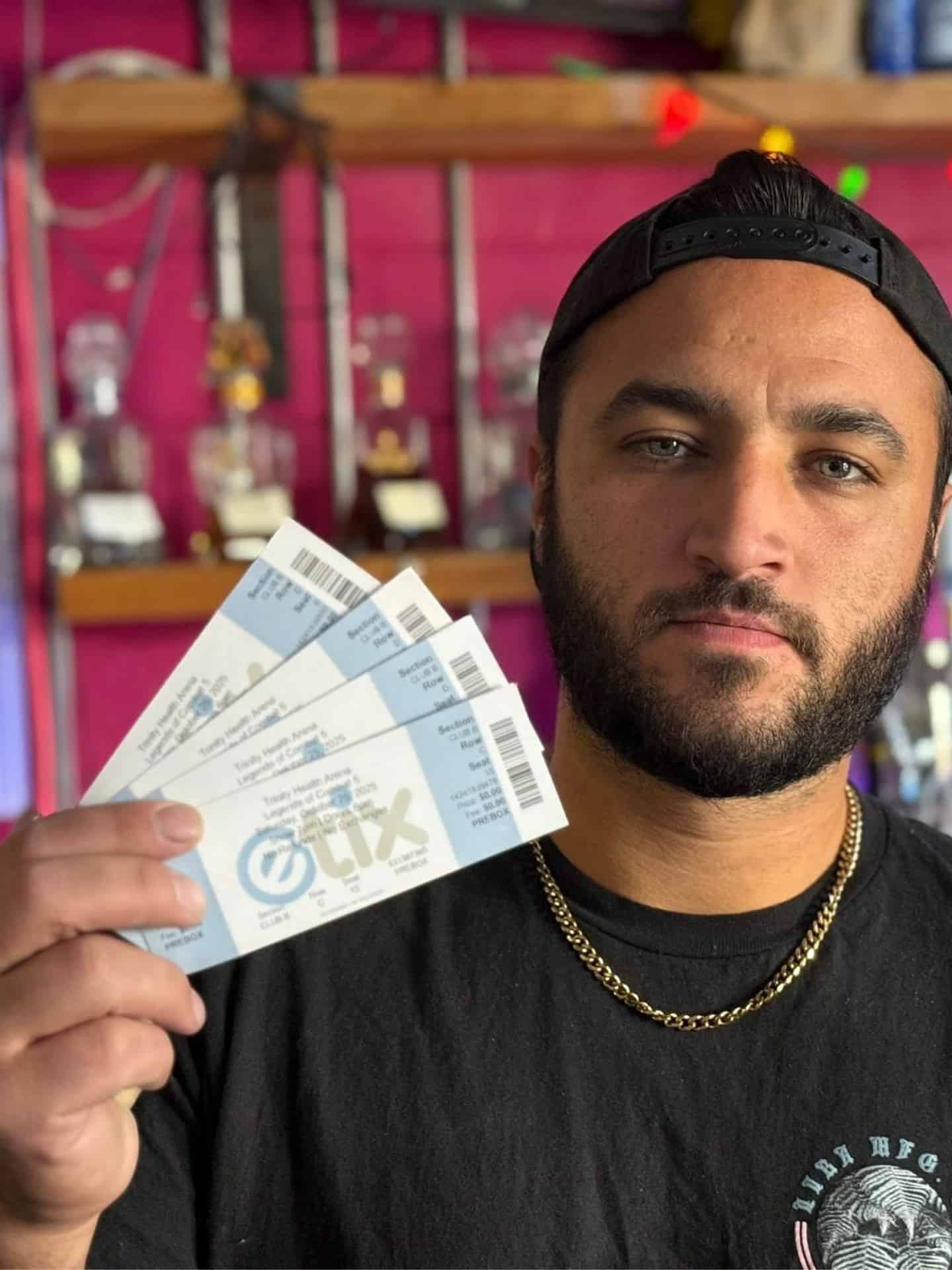 Man holding tickets at West Michigan Ironmen game or event.
