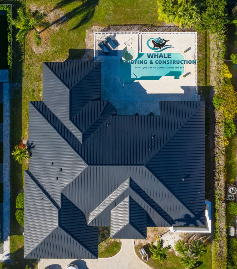 Metal Roofing Contractors 2 Aerial view of a house with a dark roof and a backyard swimming pool featuring the logo and text for Whale Roofing & Construction.