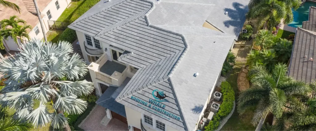 A Brief Look At The Top 12 Most Common Roofing Issues in South Florida—and How to Fix Them 1 Aerial view of a large house with a gray shingle roof, addressing common roofing issues in Florida's climate.