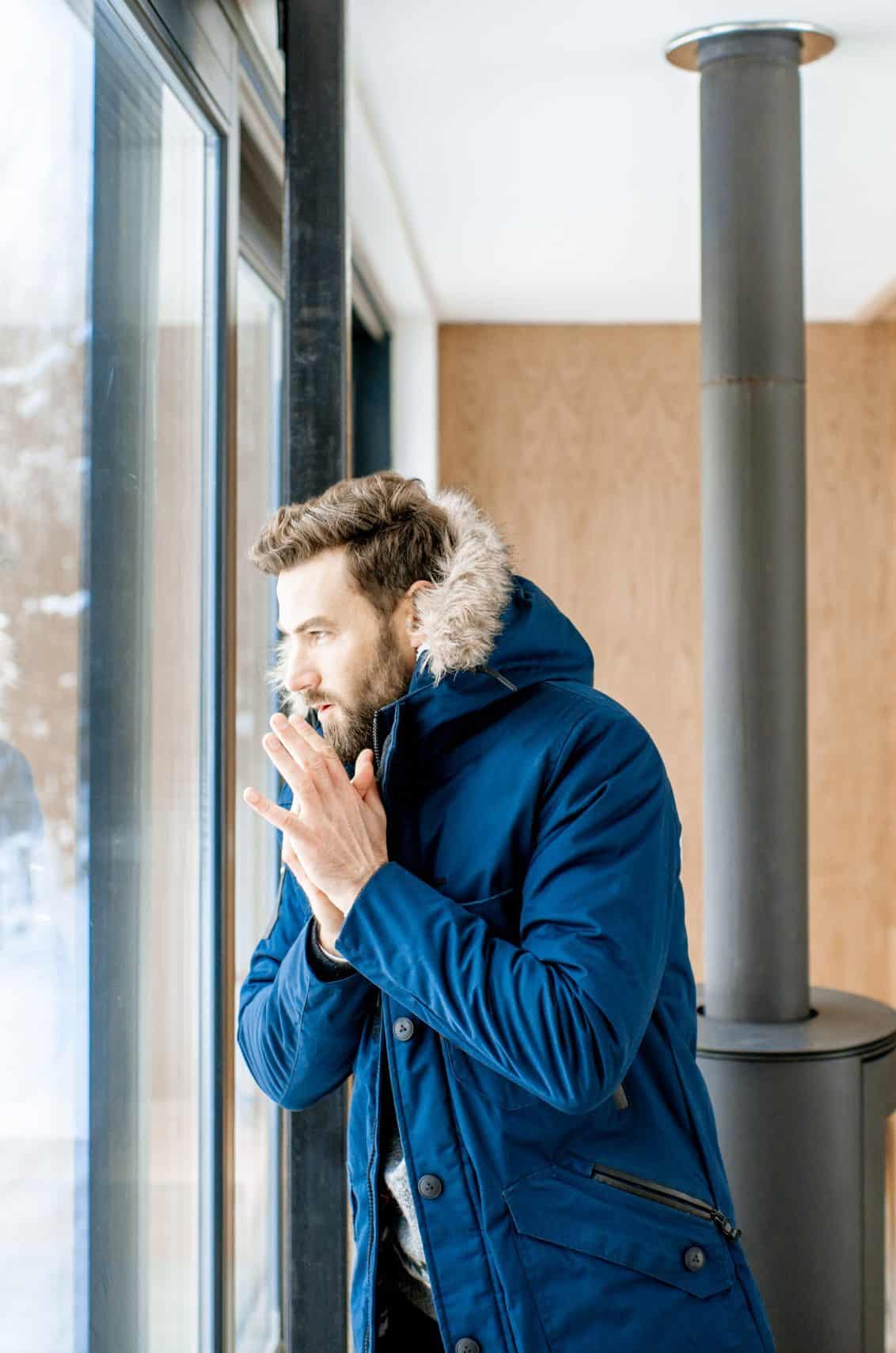 Man feeling cold at home Home in Calgary with roof condensation freezing