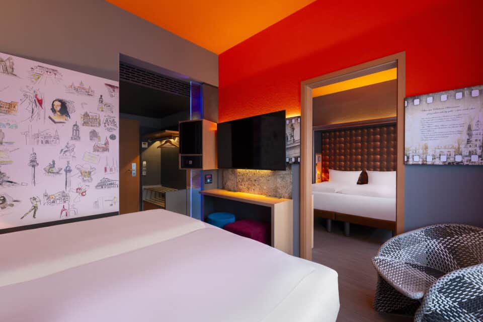 Familienzimmer-Variante: zwei Doppelzimmer mit Verbindungstür. Arbeitsplatz, TV, Minibar/Safe in Augenhöhe, offene Garderobe