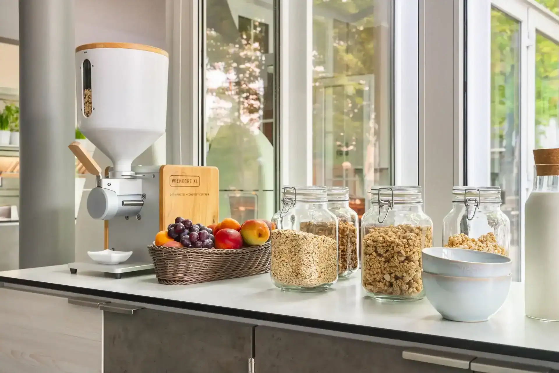 Müsli-Station mit Nussmus-Maschine der Marke "supernatural", frischem Obst, Weckgläsern mit Cerealien und Keramikschalen