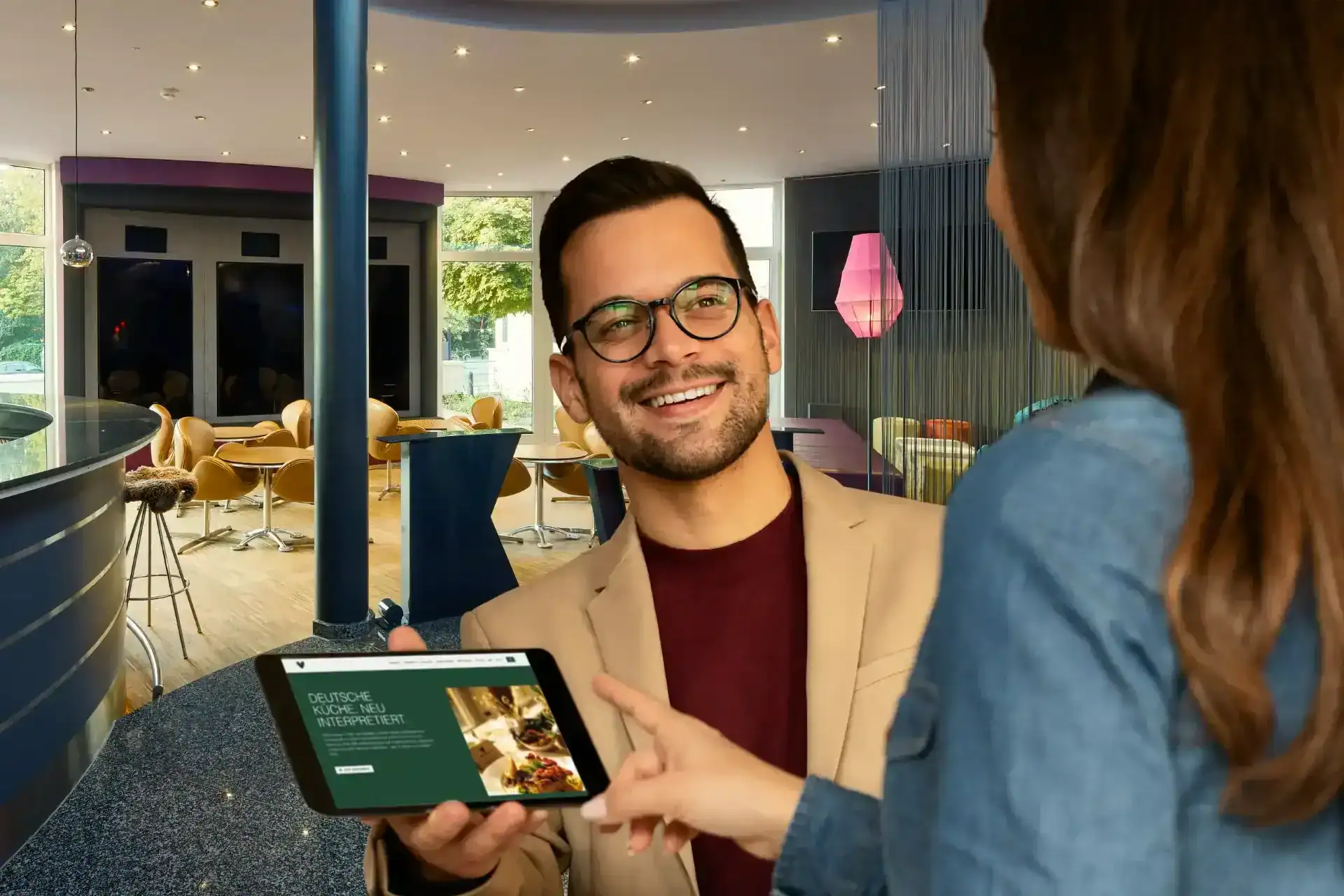 Gästeberatung mit Tablet in der modern gestalteten Lobby des Designhotels