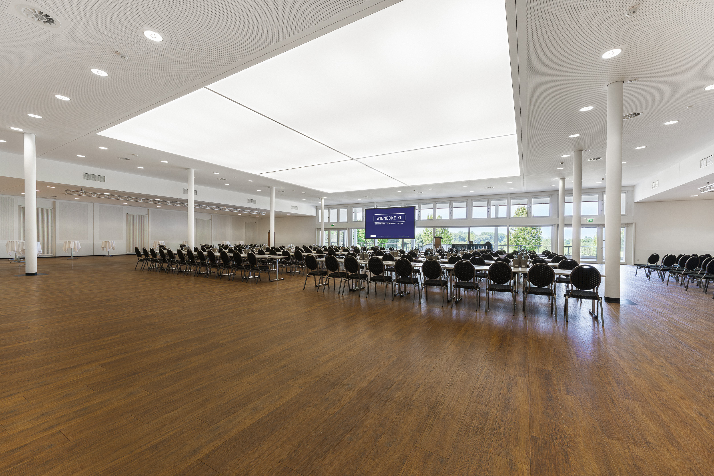 Tagungsraum mit Reihenbestuhlung, Leinwand und Panoramafenstern