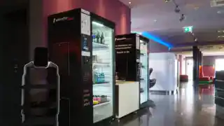 Moderne 24/7 Self-Service-Zone im Designhotel mit Service-Terminal und Snack-Automaten