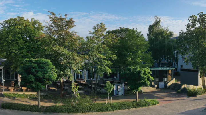 Designhotel Wienecke XI umgeben von üppigem Grün mit einladendem Außenbereich.