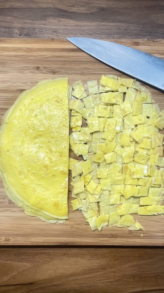 Slice egg crepes into pieces