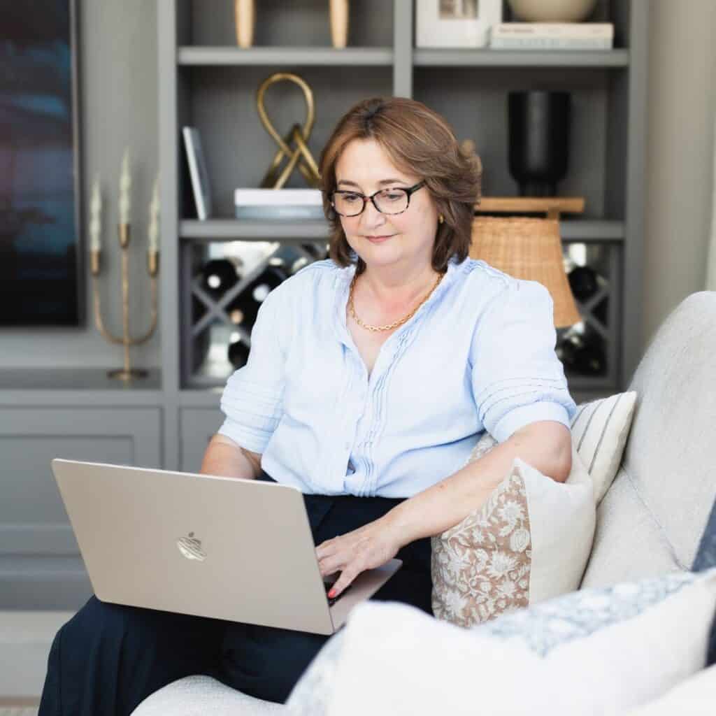 A woman working on a laptop at home, representing small business website success.