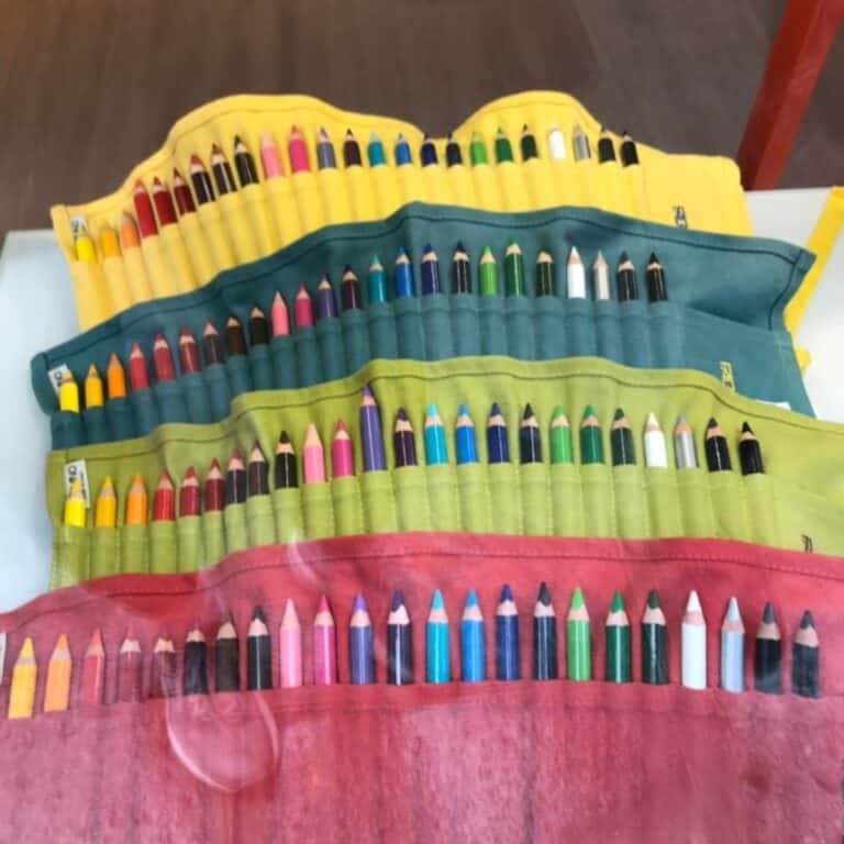 Bright colored pencil case with multiple compartments containing various colored pencils and markers.