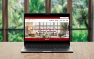 High-quality plantation shutter installation displayed on laptop screen at home setting.