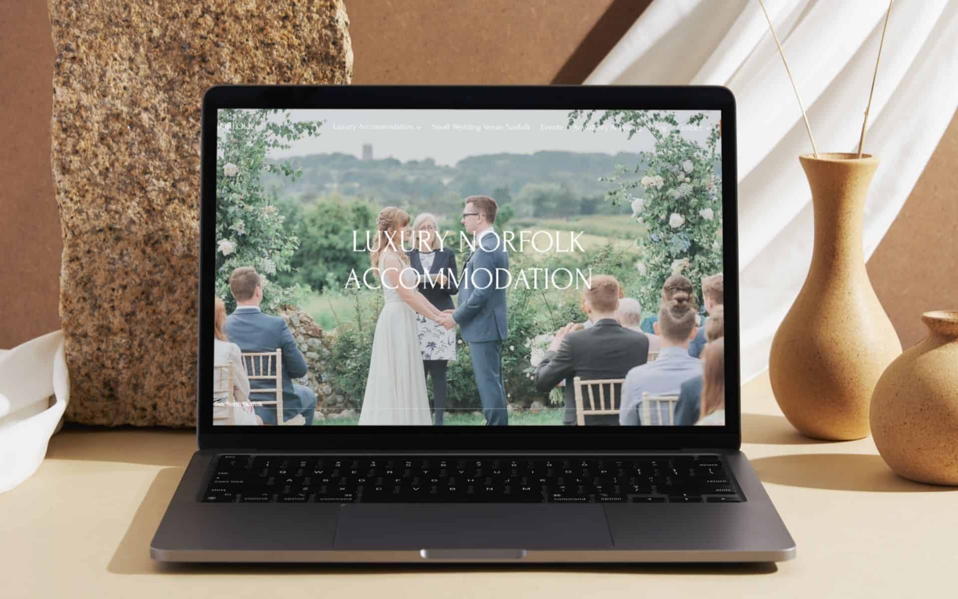 Luxury Norfolk wedding ceremony outdoors with guests, scenic countryside backdrop.