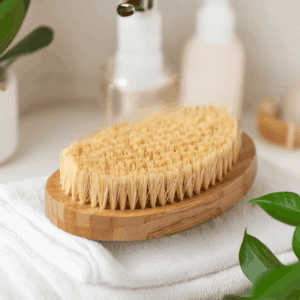 Eco-friendly teak bath brush on wooden soap dish, perfect for exfoliating skin.