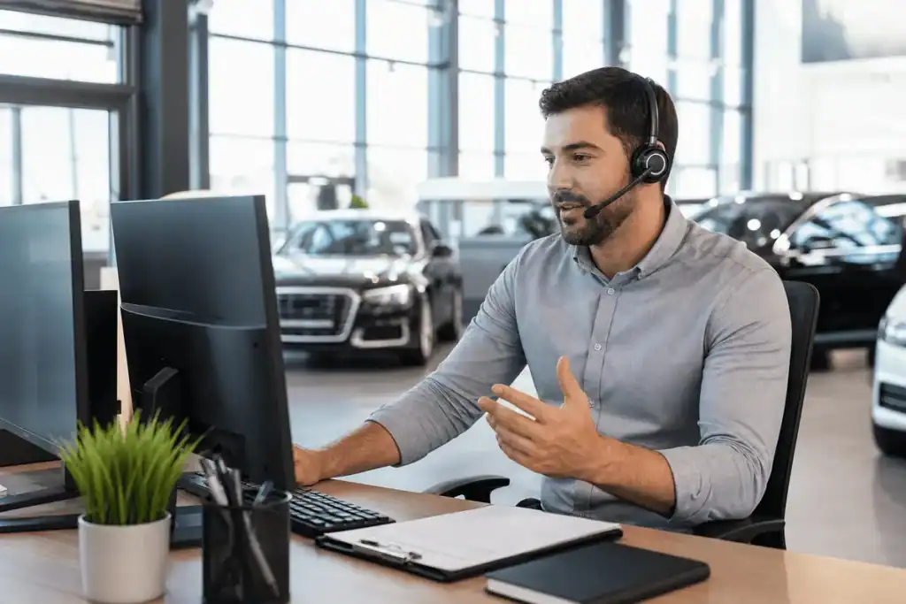 Dealership BDC agent on a call setting customer appointments inside a showroom