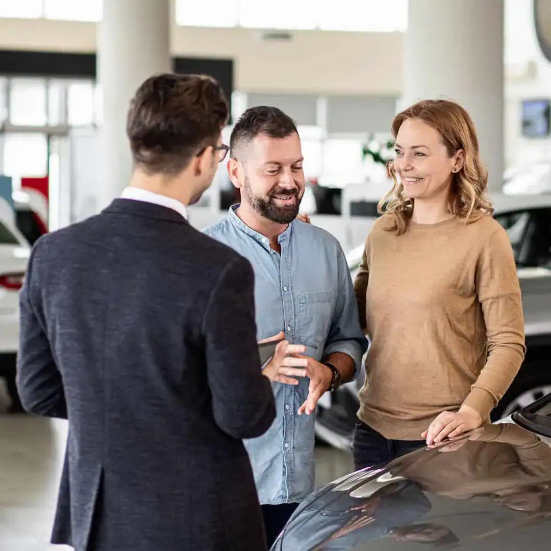 Family discussing car options at dealership, expert automotive marketing consultation.