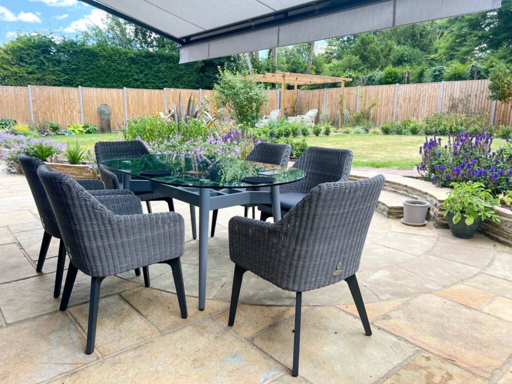 Outdoor patio dining area under a motorised awning in Kings Somborne, Stockbridge