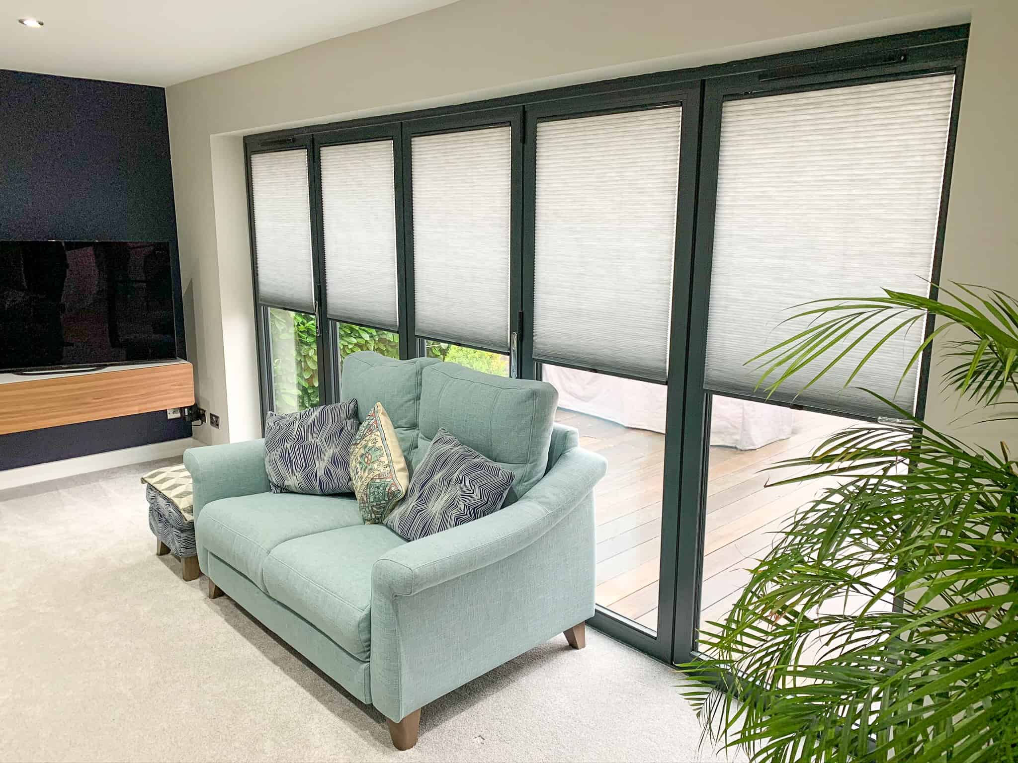 Image of pleated bifold door blinds in a living room supplied and fitted by Winchester Blinds