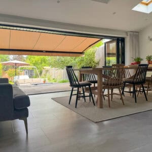 Retractable Weinor awning providing shade over a patio while helping keep the adjoining room cooler in summer.