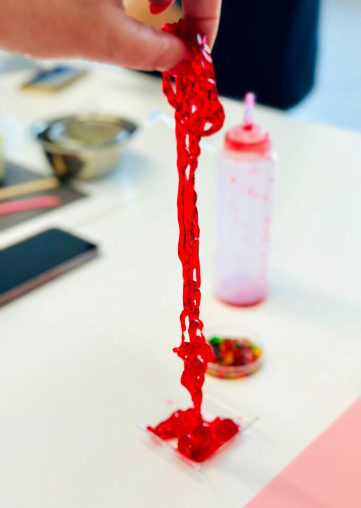 Kolorowa, kreatywna figura z czerwonej masy plastycznej na biurku, obsession magicznych projektów w Wittlab.