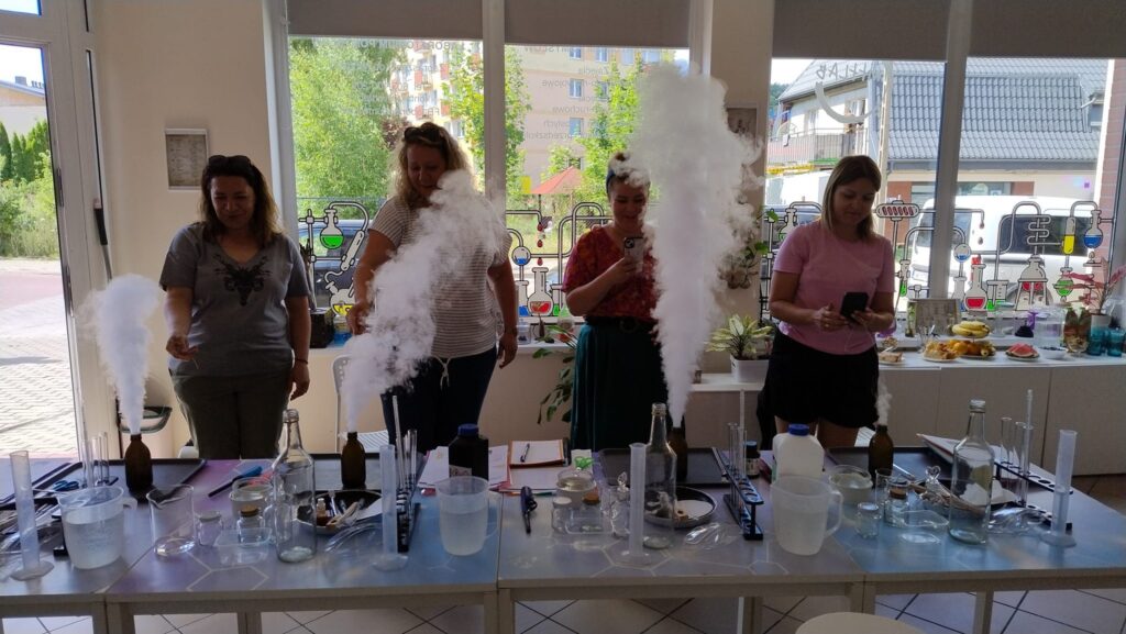 Eksperymenty chemiczne z dymem w laboratorium edukacyjnym, zaangażowane naukowczynie podczas warsztatów naukowych, kreatywne zajęcia dla dorosłych w centrum nauki Wittlab, nauka i zabawa dla każdego.