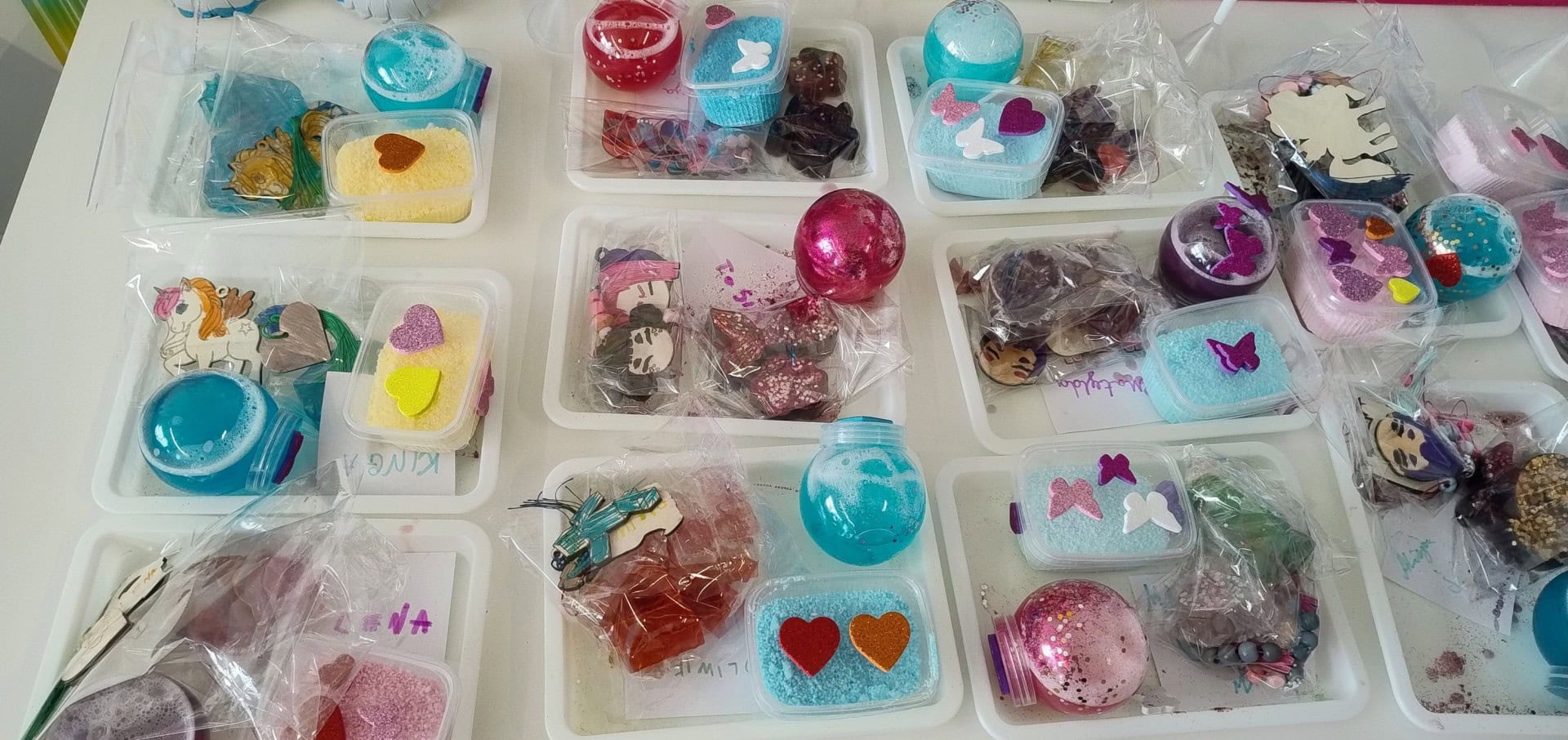 Kolorowe dekoracje i ozdoby na bazie slime i masy plastycznej dla dzieci. Kreatywne zestawy z różnymi motywami, kolorami i kształtami, idealne do rękodzieła i zabawy plastycznej.