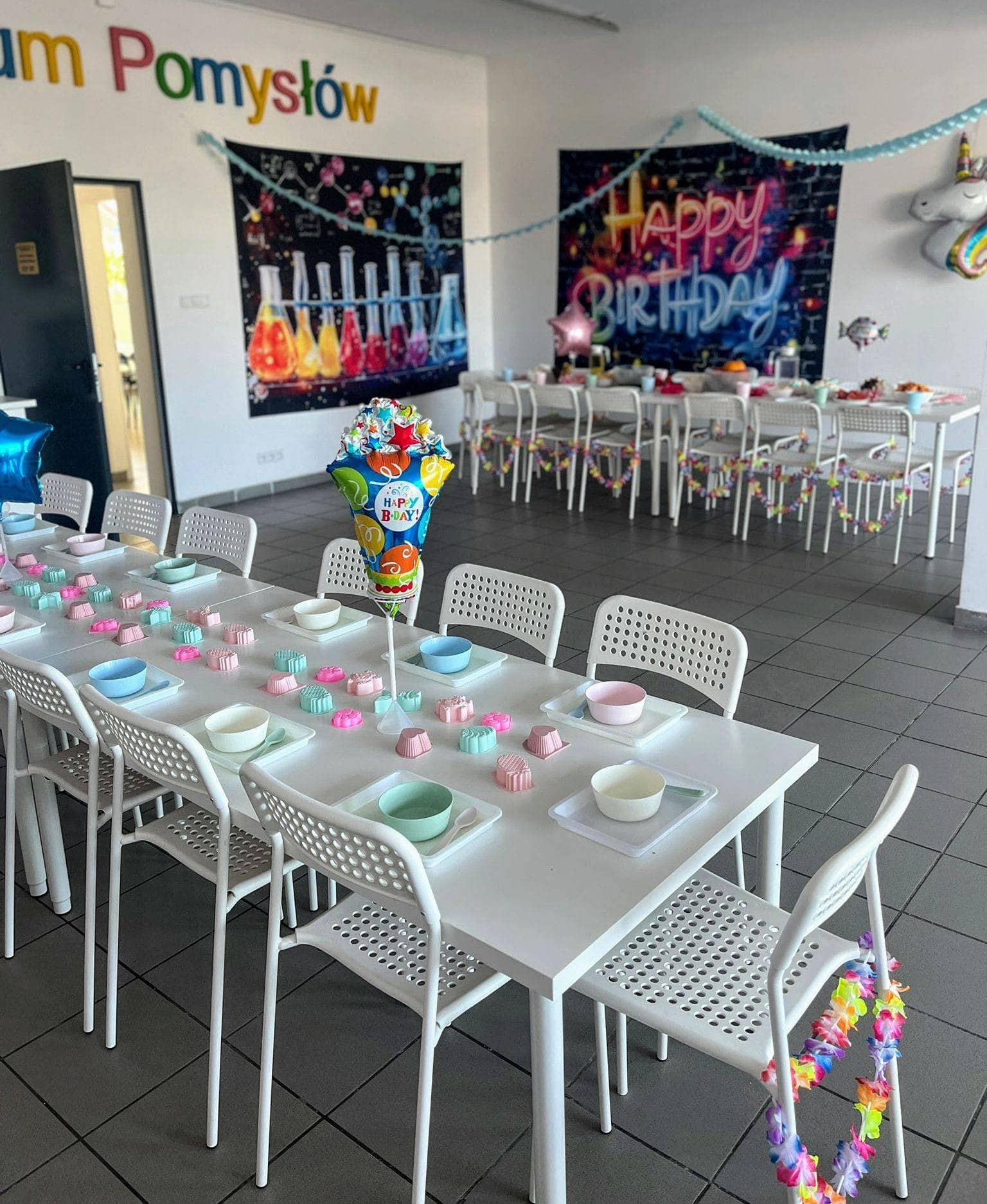 Balony urodzinowe, dekoracje imprezowe, kolorowe stoły na urodziny, aranżacja na piknik, dekoracje w stylu urodzinowym, sala zabaw dla dzieci, balony z napisem Happy Birthday, przyjęcie urodzinowe, dekoracje na imprezę, urodziny w stylu dziecięcym, pamiątki i dekoracje na urodziny, kreatywne dekoracje dziecięce, sala z balonami i dekoracjami, organizacja imprez urodzinowych, przyjęcie dla dzieci, dekoracje balonowe na urodziny, sala do zabawy, zdjęcie dekoracji urodzinowych, dekoracje na przyjęcie, aranżacja stołów na urodziny, przestrzeń eventowa dla dzieci.