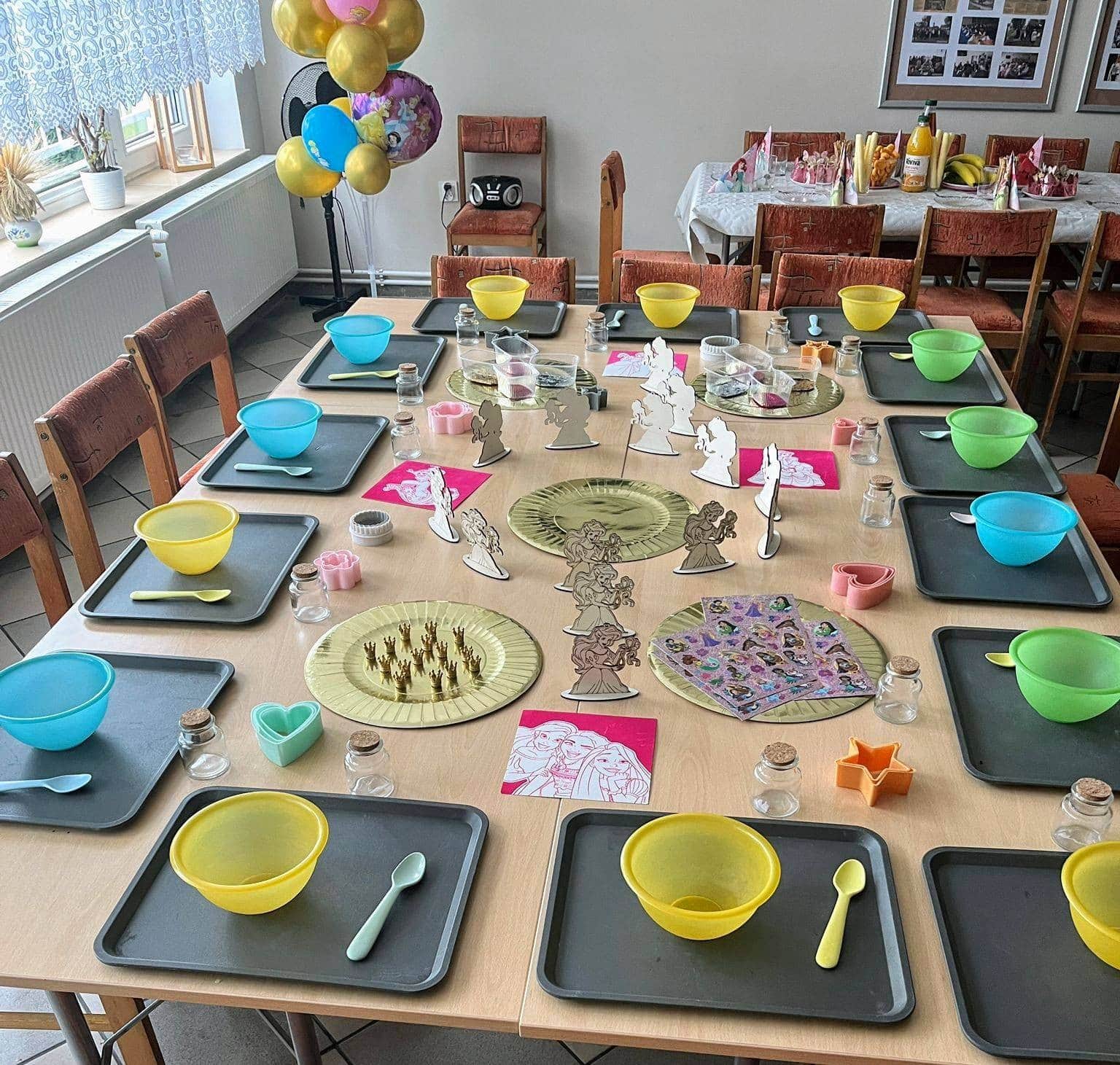 Kolorowe dekoracje i zastawa na urodzinowym stole dla dzieci, przygotowany do imprezy z motywami bajek i przyjaciół.