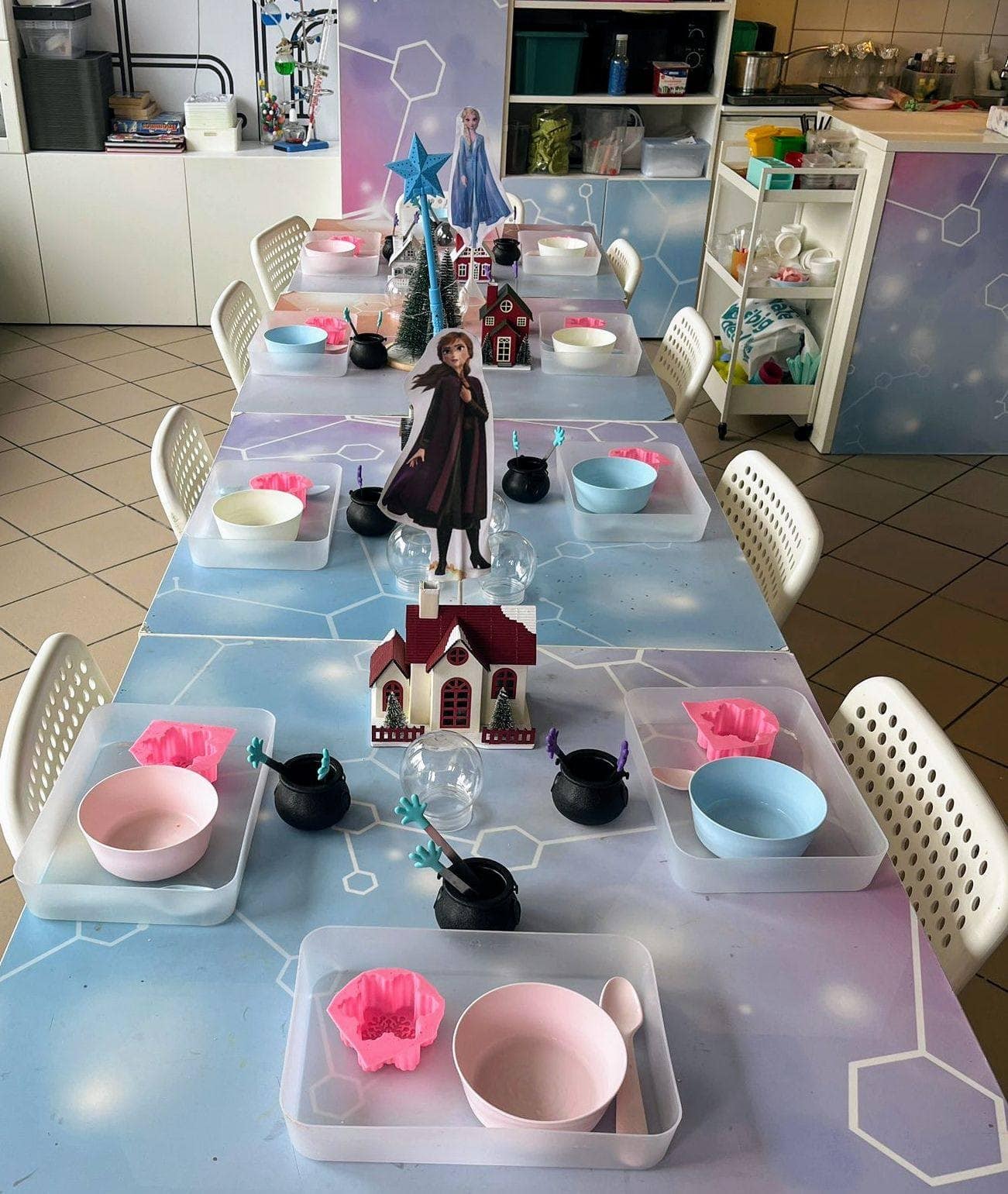 Magiczny stół do urodzin z dekoracjami z filmu Frozen, ozdobny i tematyczny, idealny na przyjęcie dla dzieci, z figurkami postaci Disneya i fantazyjnym otoczeniem.