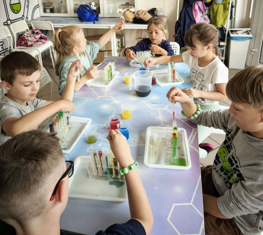 Kolorowe dzieci przeprowadzające eksperyment naukowy w sali szkolnej, badanie chemiczne w edukacji dla dzieci.