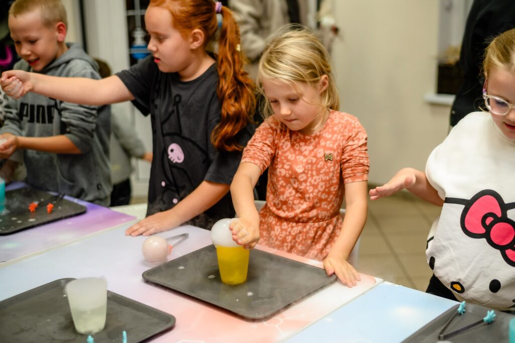 Prace naukowe dzieci podczas eksperymentów z ciekłym azotem i substancjami chemicznymi, zabawa i nauka dla dzieci w kreatywnej atmosferze.