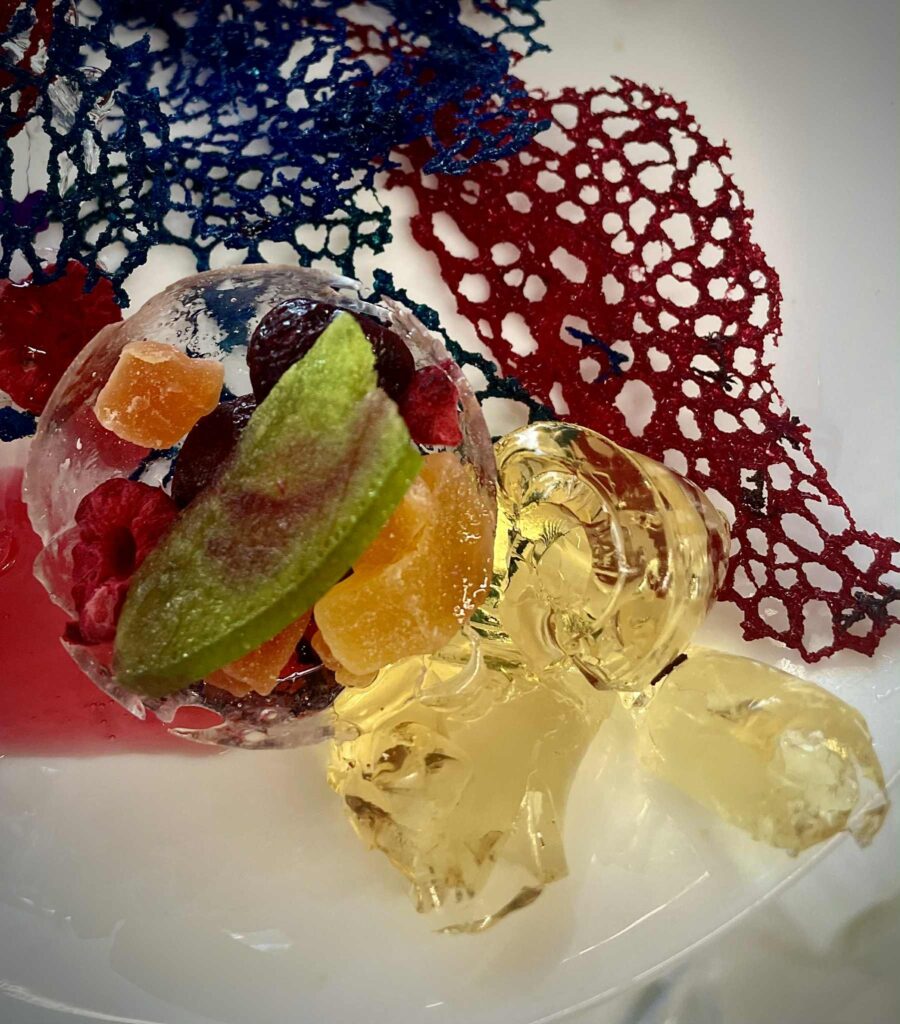 Kolorowa galaretka z owocami, dekoracja cukiernicza i ozdobne siateczki w tle, idealne na deser lub do sesji zdjęciowej, promujący słodkie wypieki i confectionery art.