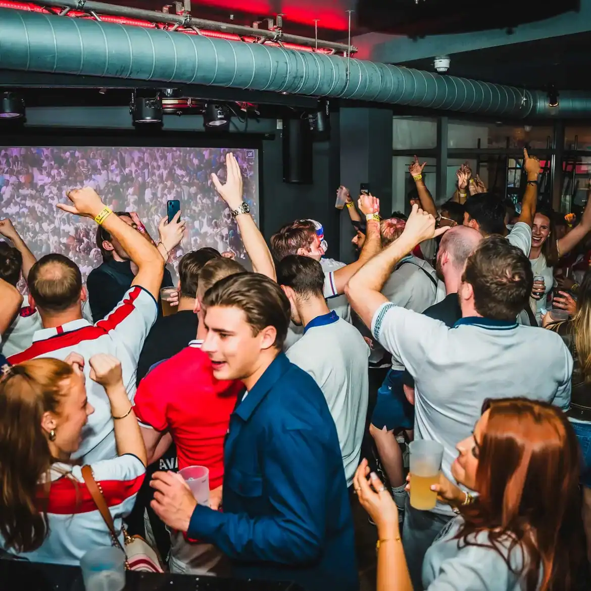 Crowd of people celebrating at Belushi's during the World Cup event.